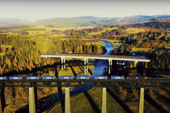 Tesco train on the Highland Main Line crossing a bridge with the A9 in background